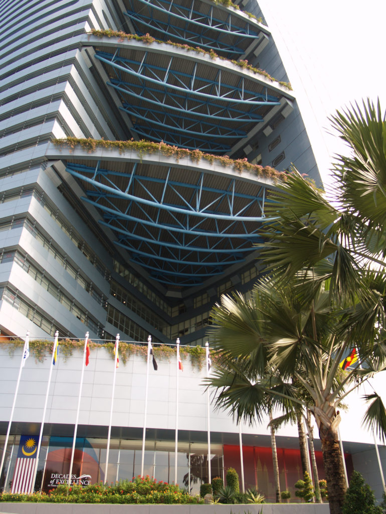 Palm and shrubs at ground level with Bougainvillea spilling over edges of planting decks projecting from tower